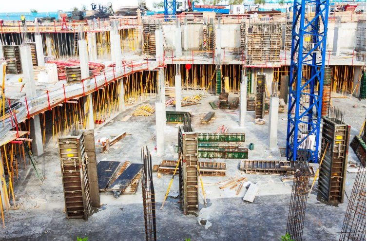 A spider crane operating in a tight urban construction site, showcasing its compact design and versatility.